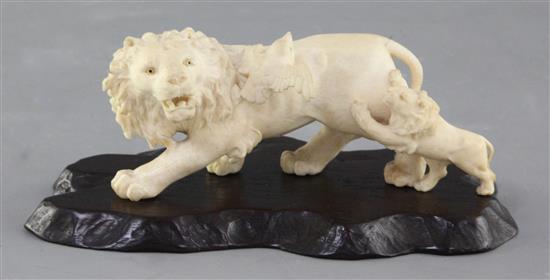 A Japanese ivory okimono of a lion and cub, early 20th century, length 13cm excl. wood stand